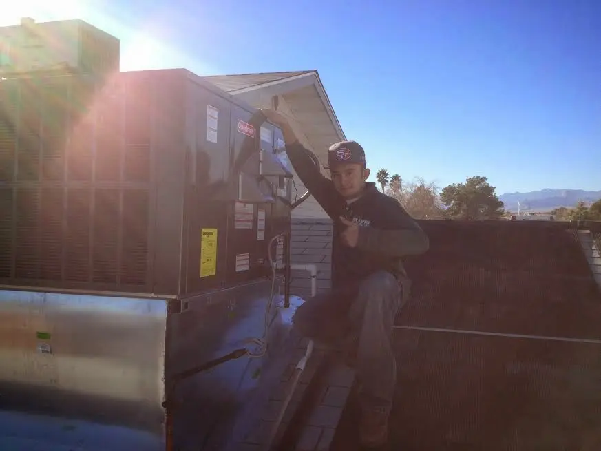 HVAC technician performing HVAC Inspection on a rooftop unit in Mableton